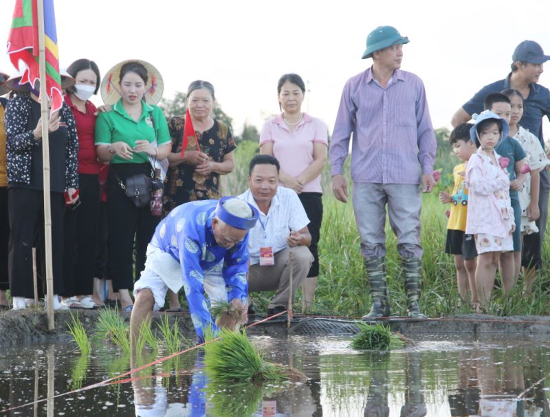 Ông chủ tế xuống ruộng trước cửa đình Cốc cấy những cây lúa đầu tiên trước sự chứng kiến của dân làng. Ông chủ tế xuống ruộng trước cửa đình Cốc cấy những cây lúa đầu tiên trước sự chứng kiến của dân làng.