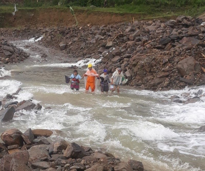 Công nhân Điện lực Than Uyên (PC Lai Châu) giúp người dân qua suối