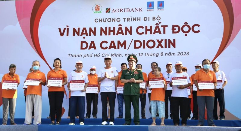 Ông Phạm Trung Kiên - Phó Trưởng Văn phòng Đại diện Agribank Khu vực miền Nam (hàng đầu, thứ năm từ trái sang) đại diện Agribank trao tặng 20 sổ tiết kiệm cho gia đình nạn nhân chất độc da cam có hoàn cảnh khó khăn