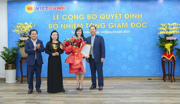 Ông Dương Nhất Nguyên, Chủ tịch HĐQT Vietbank (đầu tiên bên trái), bà Trần Thị Lâm, Nhà sáng lập, Thành viên Ban Điều hành Vietbank (thứ 2 từ trái qua) và ông Nguyễn Hữu Trung, Phó chủ tịch HĐQT Vietbank (đầu tiên bên phải) trao hoa và quyết định bổ nhiệm bà Trần Tuấn Anh