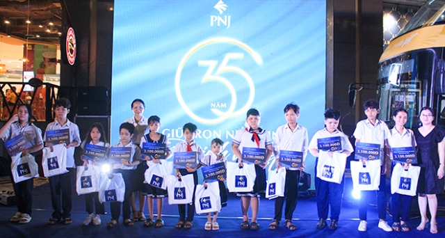 Phó Chủ tịch Hội LHPN thành phố Nguyễn Thị Huyền (áo trắng, giữa) trao quà cho các em học sinh có hoàn cảnh khó khăn trên địa bàn thành phố