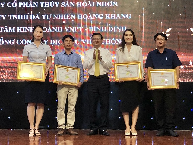Ông Nguyễn Tự Công Hoàng (đứng giữa) trao tặng Bằng khen của UBND tỉnh Bình Định cho các tổ chức.