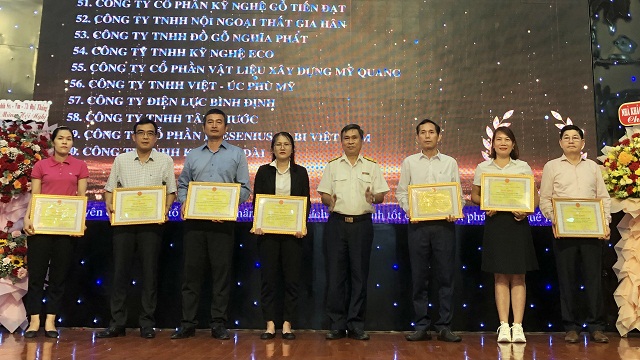 Ông Đào Hữu Phúc (thứ 6 từ trái qua) trao tặng Giấy khen của Cục Thuế Bình Định cho các tổ chức, cá nhân.
