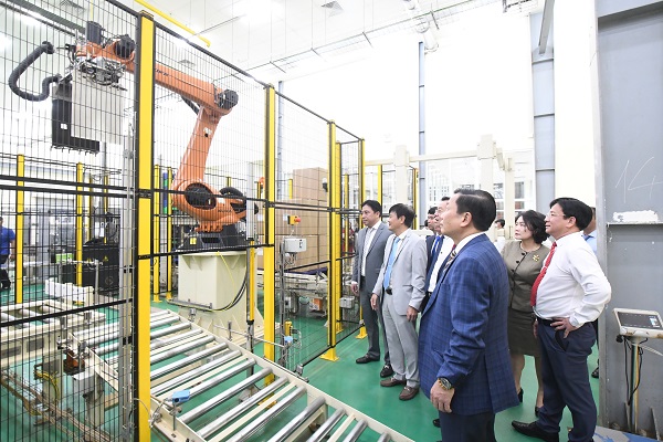Các đại biểu đi tham quan một công đoạn sử dụng Robot của nhà máy