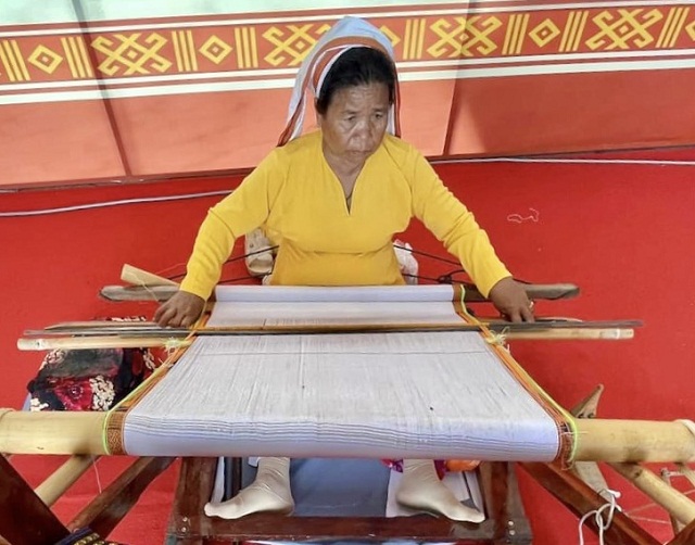 Một nghệ nh&acirc;n tr&igrave;nh diễn kỹ thuật dệt vải.