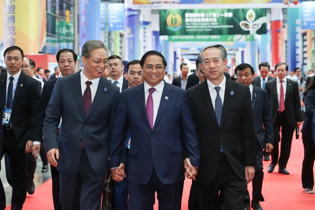 Thủ tướng Phạm Minh Chính, Bí thư tỉnh Quảng Tây (trái), Đại sứ Trung Quốc tại Việt Nam (phải) tham quan các gian hàng tại Hội chợ - Ảnh: VGP/Nhật Bắc