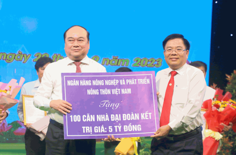Ông Lê Viết Quyền – Giám đốc Agribank Hậu Giang (bên phải) trao biểu trưng 100 căn nhà Đại đoàn kết trị giá 5 tỷ đồng