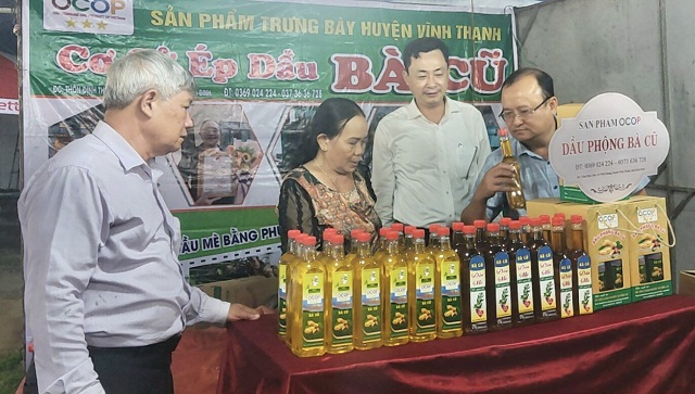 Các thành viên Ban tổ chức tham quan gian hàng của Cơ sở Ép dầu Bà Cũ. Trong ảnh (từ trái qua): Ông Hồ Sỹ Dũng, ông Võ Mai Hưng (thứ 3), ông Lê Minh Thông (thứ 4).