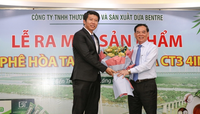 Ông Trần Ngọc Tam (bên phải) - Chủ tịch UBND tỉnh Bến Tre chúc mừng sản phẩm đầu tiên tại Việt Nam được chế biến từ mộng dừa.