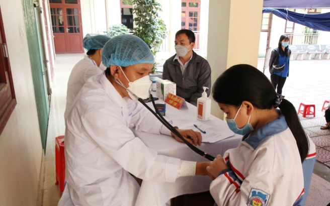 Nhân viên y tế khám sức sức khỏe cho học sinh.
