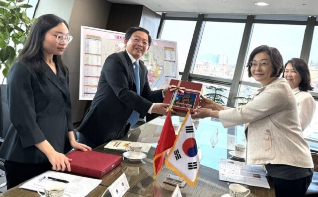 Ông Hồ Quốc Dũng (bên trái) tặng quà lưu niệm cho bà Park Hee Young. Ảnh: Sở KH&ĐT BĐ.