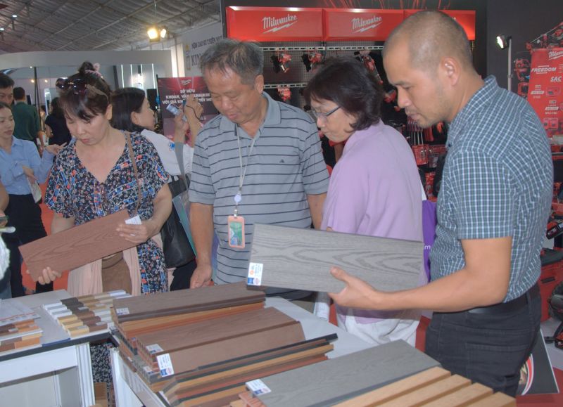 Khách tham quan tại gian hàng trưng bày sản phẩm gỗ công nghiệp.