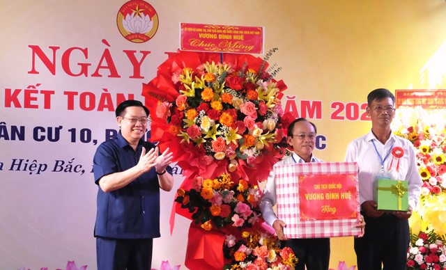 Chủ tịch Quốc hội Vương Đình Huệ (bên trái) tặng hoa, quà chúc mừng khu dân cư số 10