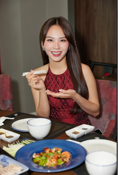 Hoa hậu Mai Phương thưởng thức món da vịt cuốn bánh pía thơm ngon.