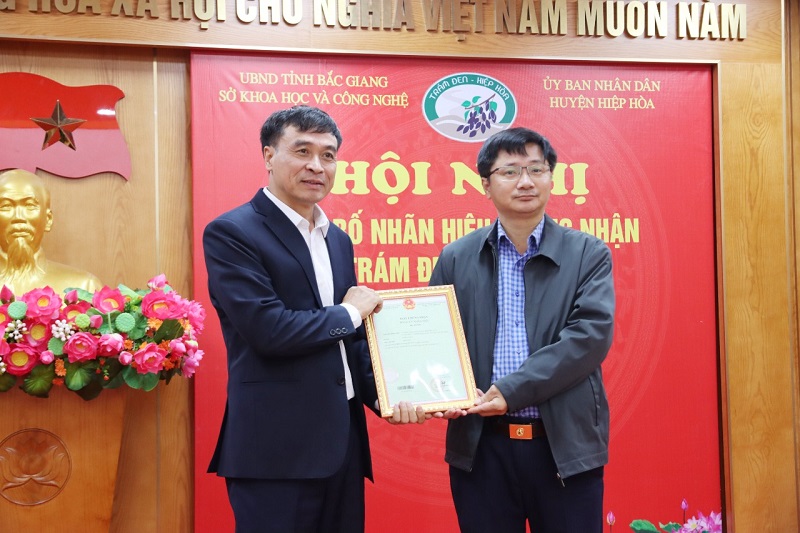 Ông Lương Vũ Thắng, Phó trưởng Phòng quản lý Khoa học công nghệ cơ sở và Sở hữu trí tuệ trao Giấy chứng nhận đăng ký nhãn hiệu cho UBND huyện Hiệp Hòa