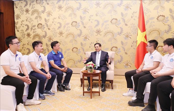 Thủ tướng Phạm Minh Chính chúc mừng các sinh viên xuất sắc giành giải thưởng tại COP28. Ảnh: Dương Giang/TTXVN