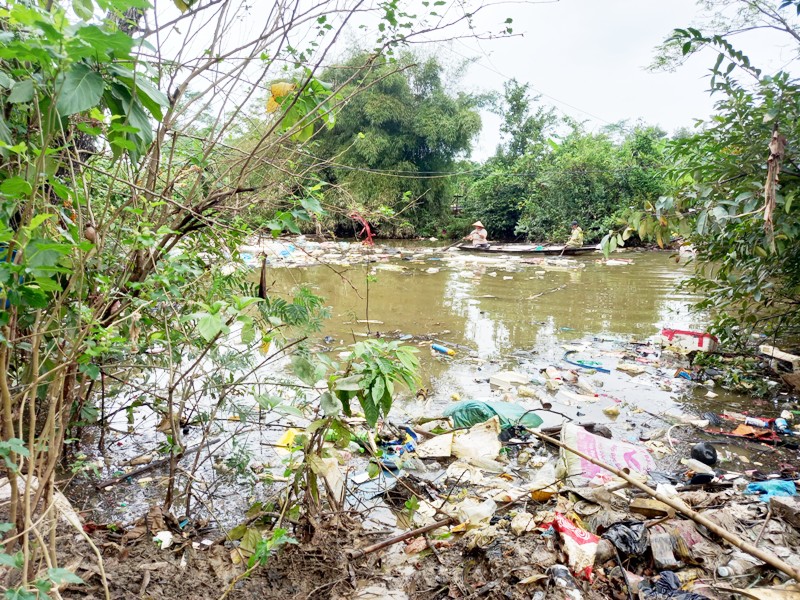 Dùng ghe vớt rác tồn đọng sau lũ lụt