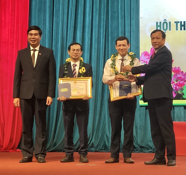 Các ông Lâm Hải Giang (bìa trái) và Lê Công Lương (bìa phải) trao giải Nhất cho nhóm tác giả của Bệnh viện Đa khoa tỉnh Bình Định.