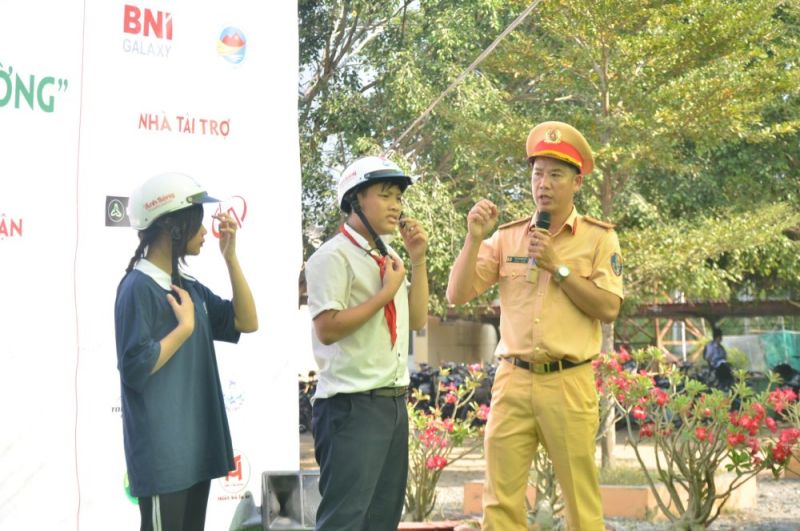 Thiếu tá Cao Thanh Vũ – Cán bộ tuyên truyền phòng CSGT, công an tỉnh Tây Ninh hướng dẫn các em học sinh cách đội mũ bảo hiểm đúng cách