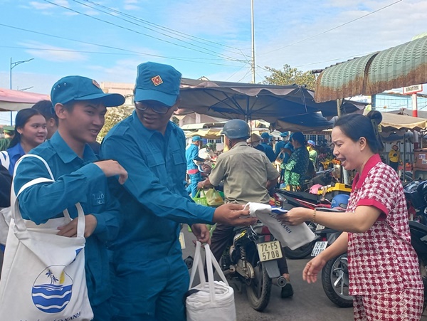 Chị Trần Cẩm Vân nhận túi vải từ lực lượng dân quân