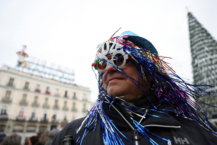 Một người đàn ông đeo kính mừng năm mới 2024 trong buổi diễn tập cho lễ đón giao thừa tại quảng trường Puerta del Sol nổi tiếng ở Madrid, Tây Ban Nha, ngày 31/12 - Ảnh: Reuters