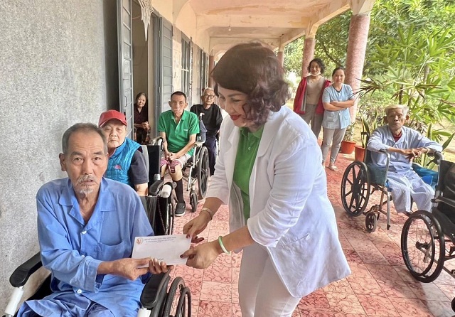 Bà Đồng Thị Ánh trao quà Tết cho bệnh nhân phong. Ảnh: Lâm Vy