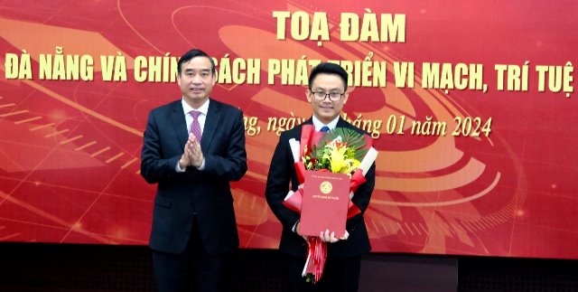 Ông Lê Trung Chinh, Chủ tịch UBND TP Đà Nẵng (bìa trái), trao quyết định cho ông Lê Hoàng Phúc, Giám đốc Trung tâm Nghiên cứu, đào tạo thiết kế vi mạch và trí tuệ nhân tạo