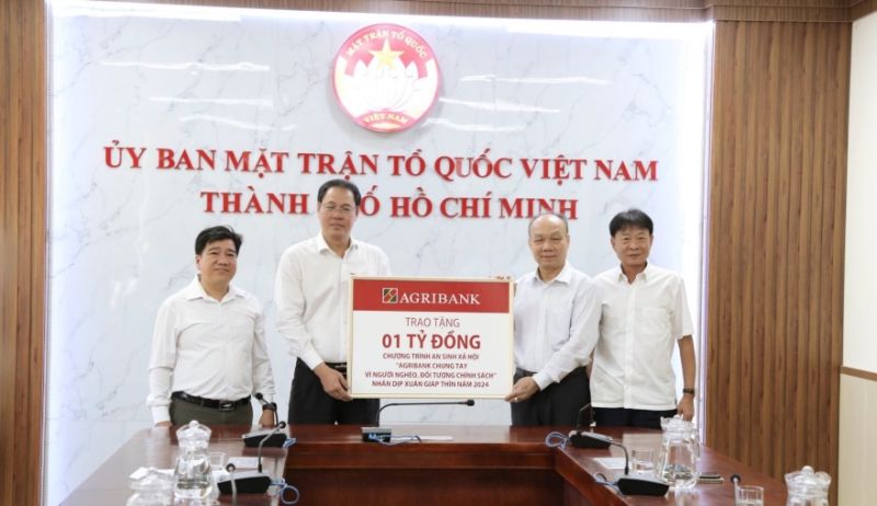 Ông Nguyễn Minh Trí - Thành viên Hội đồng Thành viên, Trưởng Văn phòng đại diện Agribank khu vực miền Nam (bên phải) trao biển tượng trưng tặng kinh phí an sinh xã hội