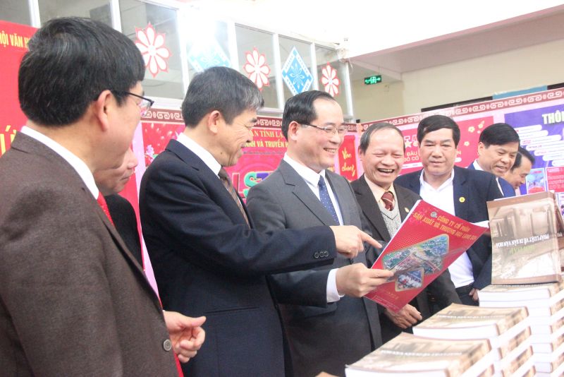 Phó Chủ tịch Thường trực UBND tỉnh Lạng Sơn (đứng giữa) cùng các đại biểu tham quan các gian trưng bày tại Hội báo Xuân