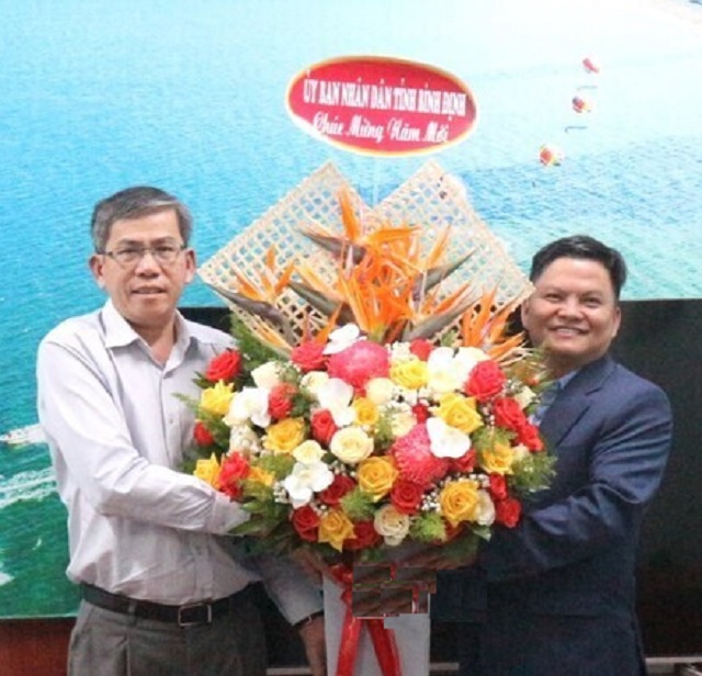 Ông Phạm Ngọc Thái (bìa trái) tặng hoa chúc Tết dại diện tạp chí Du lịch. Ảnh: K.Vy.