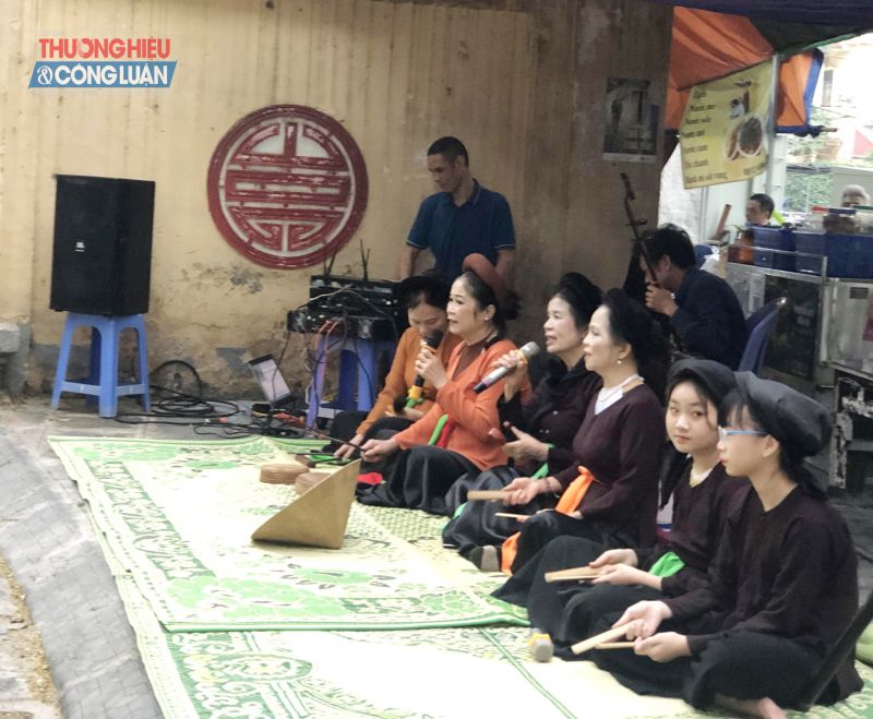 Nhóm văn nghệ của đình, chùa Quan Nhân ngồi biểu diễn hát Sẩm, Chầu Văn phục vụ người đi chợ.