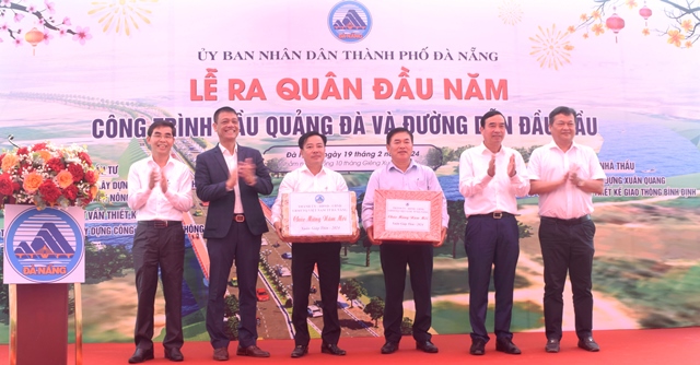 Chủ tịch UBND thành phố Lê Trung Chinh (thứ 2, từ phải sang) tặng quà động viên các nhà thầu thi công công trình cầu Quảng Đà và đường dẫn đầu cầu.