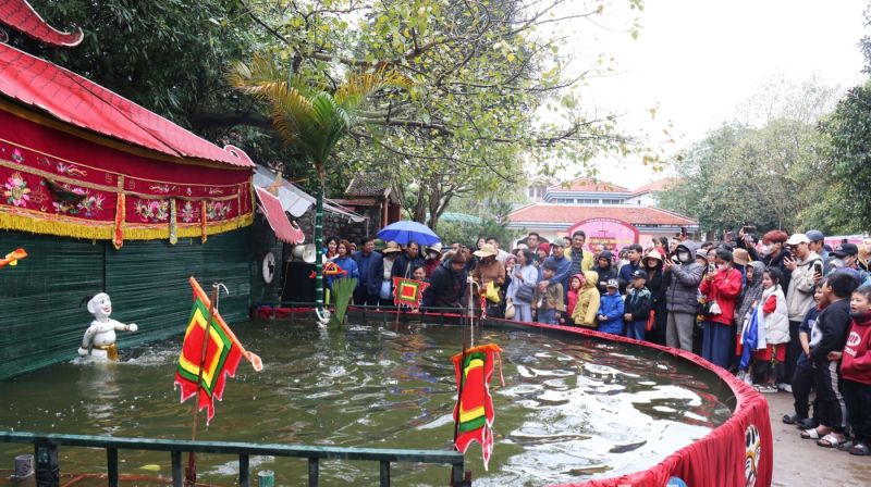 Du khách xem biểu diễn múa rối nước Đồng Ngư ở chùa Phật Tích.