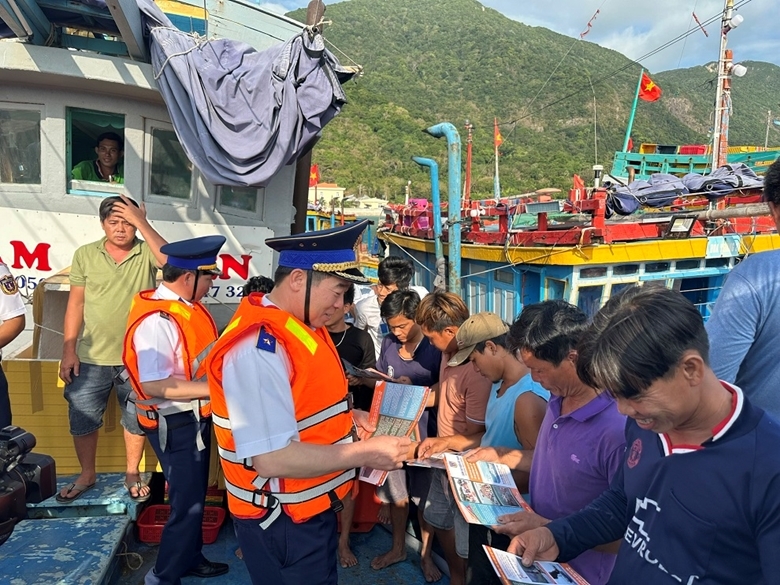 Lực lượng Cảnh sát biển Việt Nam phát tờ rơi tuyên truyền về phòng, chống khai thác IUU cho bà con ngư dân. (Ảnh: Minh Hà)