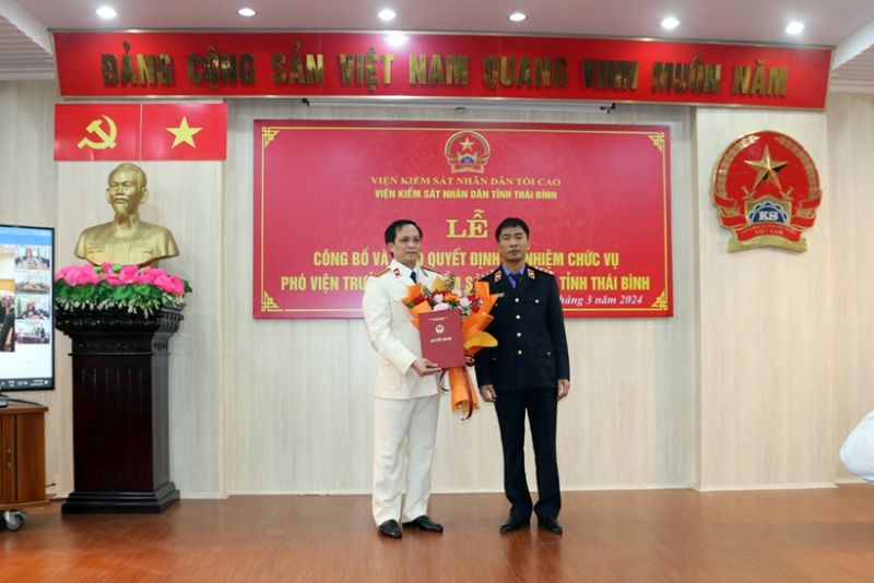 Phó Viện trưởng VKSND tối cao Nguyễn Duy Giảng trao quyết định và tặng hoa chúc mừng đồng chí Nguyễn Anh Đức.