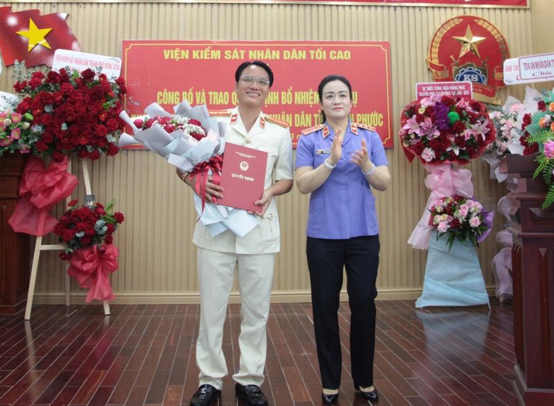 Đồng chí Nguyễn Hải Trâm, Phó Viện trưởng VKSND tối cao trao quyết định và tặng hoa chúc mừng đồng chí Ngô Văn Đạt