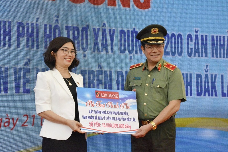 Bà Từ Thị Kim Thanh - Thành viên Hội đồng thành viên Agribank (bên trái) trao biểu trưng hỗ trợ kinh phí cho chương trình