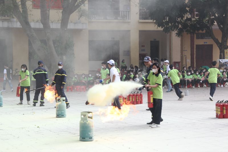Các em học sinh được hướng dẫn thao tác và sử dụng bình cứu hỏa để chữa cháy