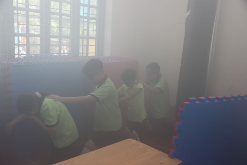 Các em học sinh thực hành thoát khỏi phòng kín khi có cháy