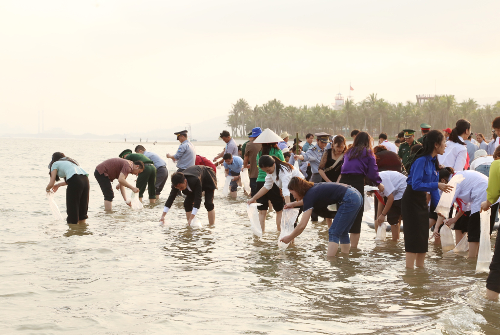 Đông đảo đại biểu, các em học sinh tham gia thả giống thủy sản tại buổi lễ.