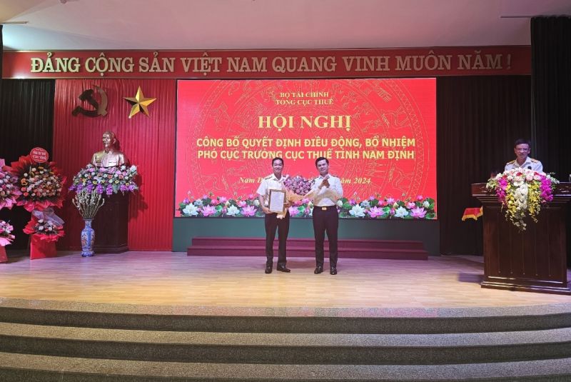 Phó Tổng Cục trưởng cục Thuế Vũ Chí Hùng (bên phải) trao quyết định điều động, bổ nhiệm Phó Cục trưởng Cục Thuế tỉnh Nam Định cho đồng chí Vũ Ngọc (bên trái)