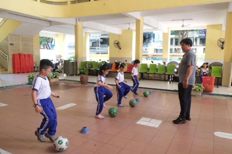 Học sinh Trường tiểu học Nguyễn Bỉnh Khiêm, quận 1, TP.HCM học thể dục ở khu vực sảnh của trường để tránh nắng nóng - Ảnh: NGỌC PHƯỢNG