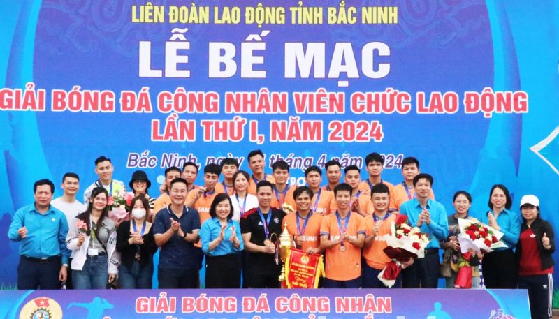 Chủ tịch LĐLĐ tỉnh Nguyễn Thị Vân Hà (thứ 5 từ trái qua) trao Cúp vô địch ở nội dung bóng đá nam cho Công ty TNHH Samsung Electronics Việt Nam.