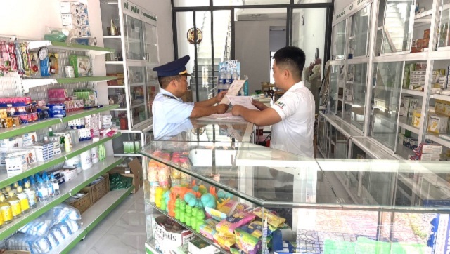 Lực lượng QLTT Gia Lai (bên trái) kiểm tra một cơ sở kinh doanh dược. Ảnh: Lê Phú.