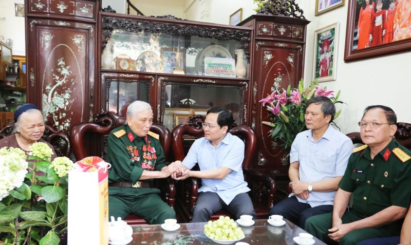 Bí thư Tỉnh ủy Nguyễn Anh Tuấn (thứ 3 từ phải qua) ân cần thăm hỏi sức khỏe của thương binh La Văn Din.