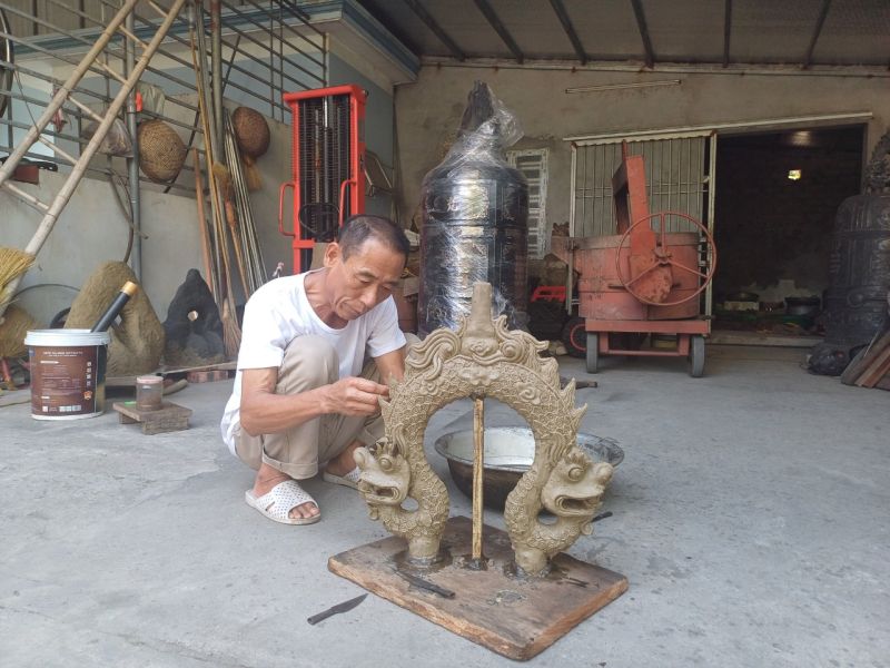 Ông Nguyễn Văn Lục đang say sưa nặn sáp tạo hình mẫu cho tai chuông
