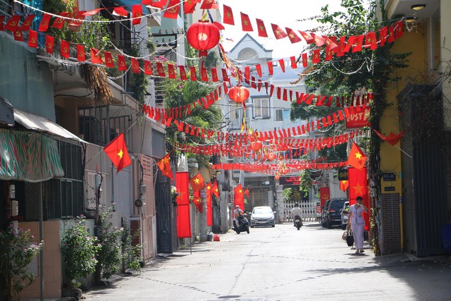 Một con hẻm ở Quận 1 rực đỏ với cờ và hoa - Ảnh: VGP/Hồng Phong