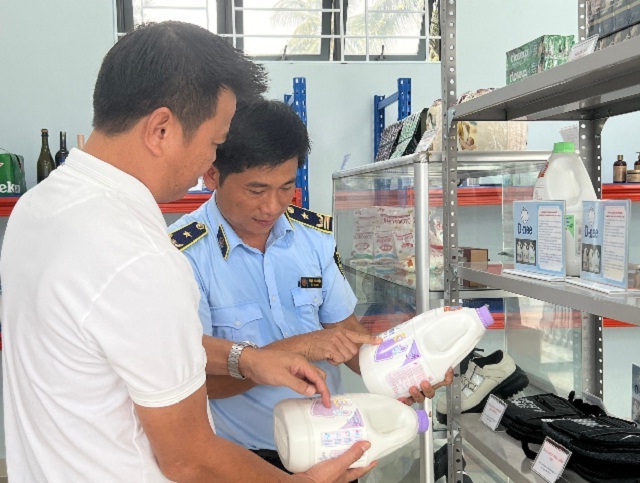 Viên chức Cục QLTT tỉnh Phú Yên (bên phải) hướng dẫn người tiêu dùng cách phân biệt hàng thật, hàng giả. Ảnh: Tr-Huỳnh