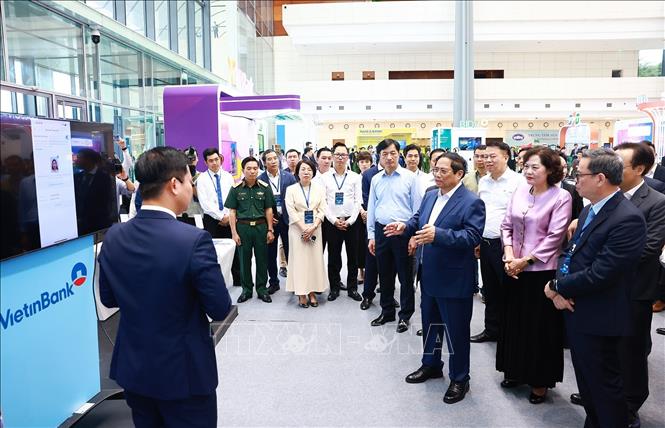 Thủ tướng Phạm Minh Chính tham quan trưng bày về ứng dụng chuyển đổi số trong lĩnh vực ngân hàng.