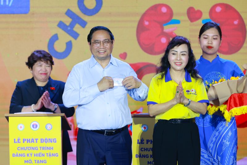 Chủ tịch Hội Vận động hiến tặng mô tạng, bộ phận cơ thể người Việt Nam trao cho Thủ tướng thẻ đăng ký hiến tặng mô, tạng. Ảnh: VGP